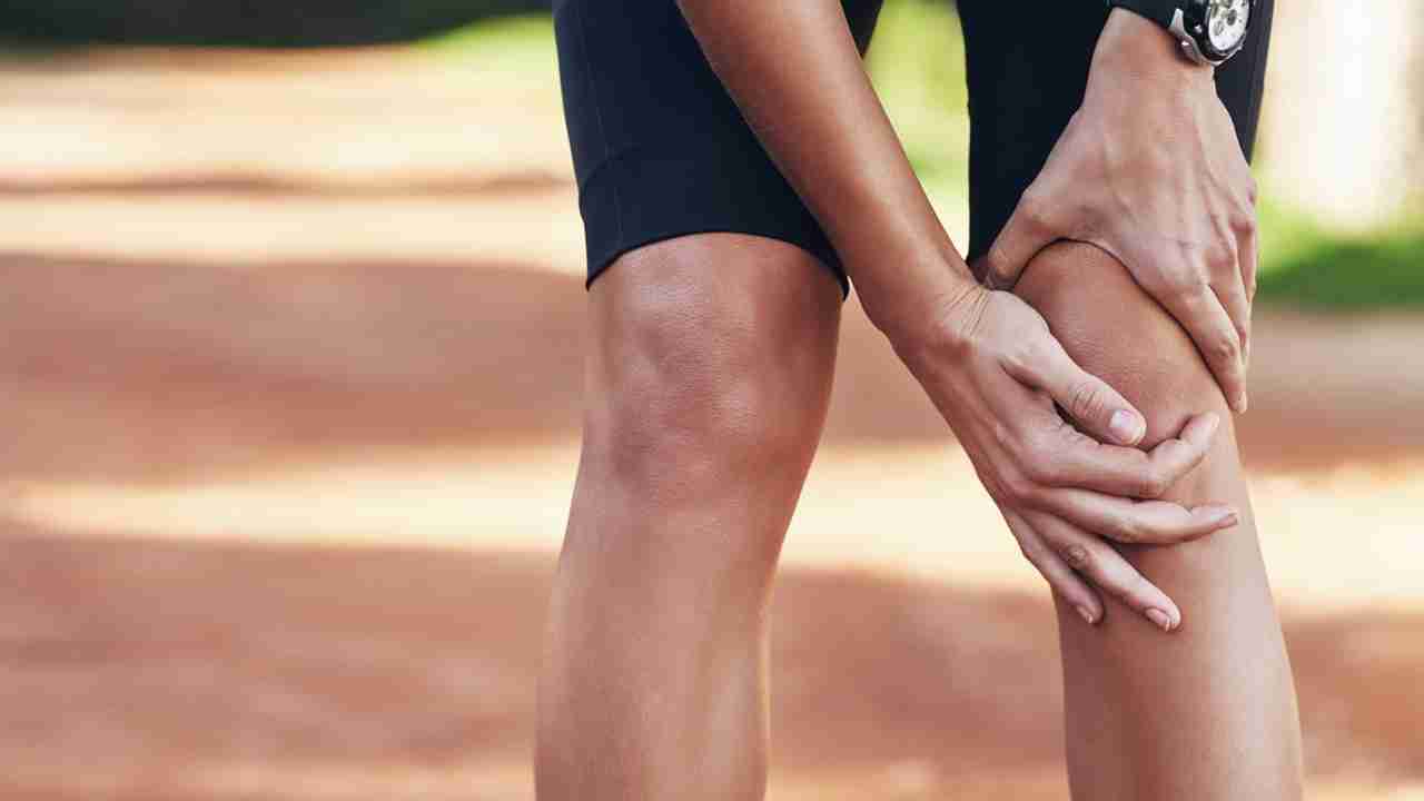 Runner holding knee in pain showing runner's knee injury and patellofemoral pain syndrome