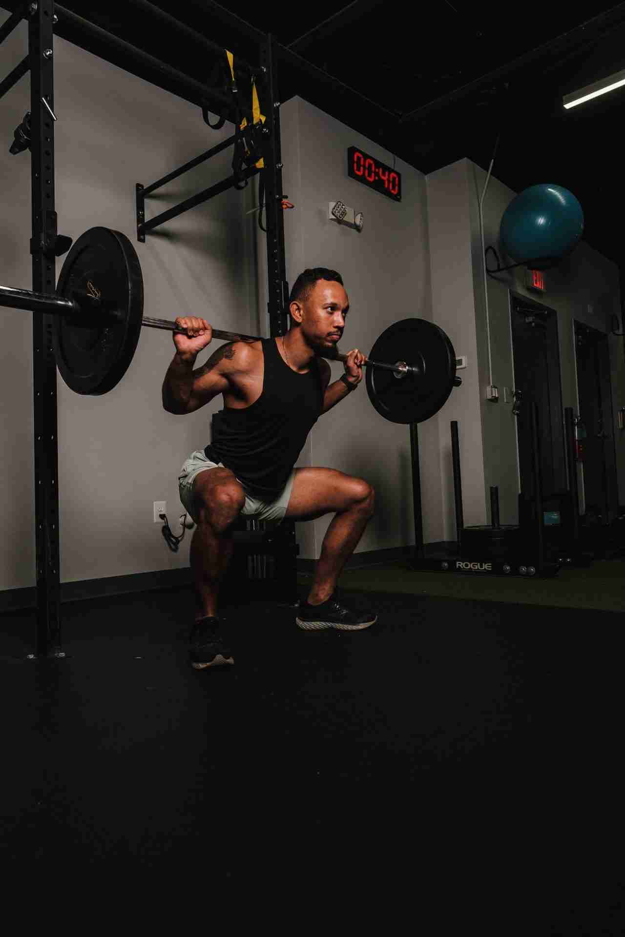 Man performing a barbell back squat, a core functional strength training exercise