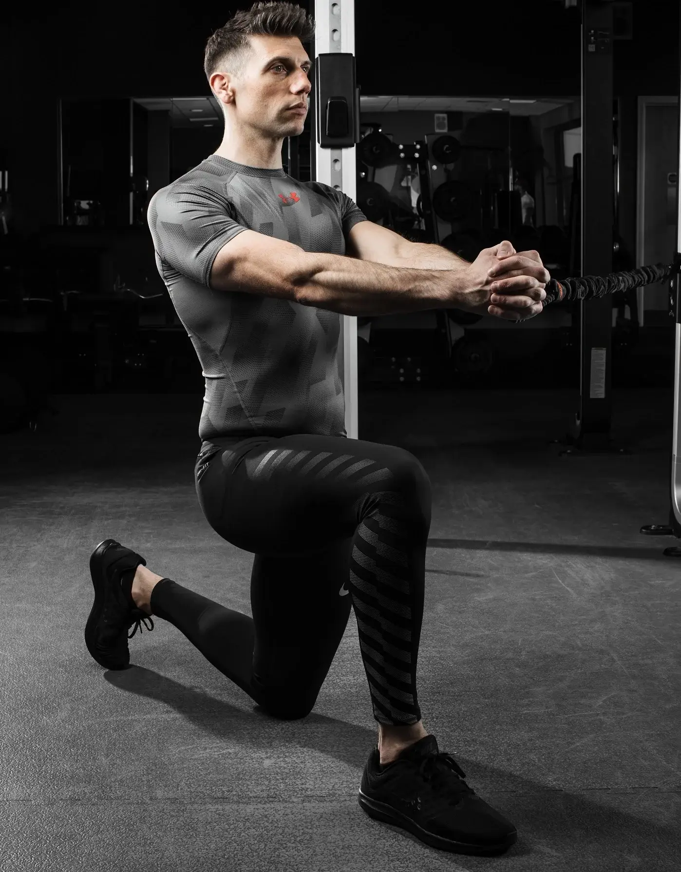 Man performing a Pallof press anti-rotation exercise with a resistance band