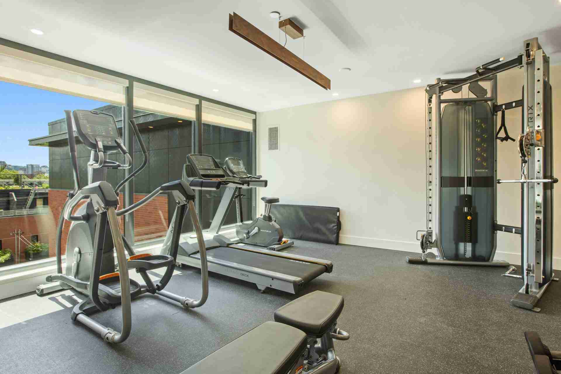 Home gym with elliptical machine in foreground and treadmill behind — treadmill vs elliptical comparison
