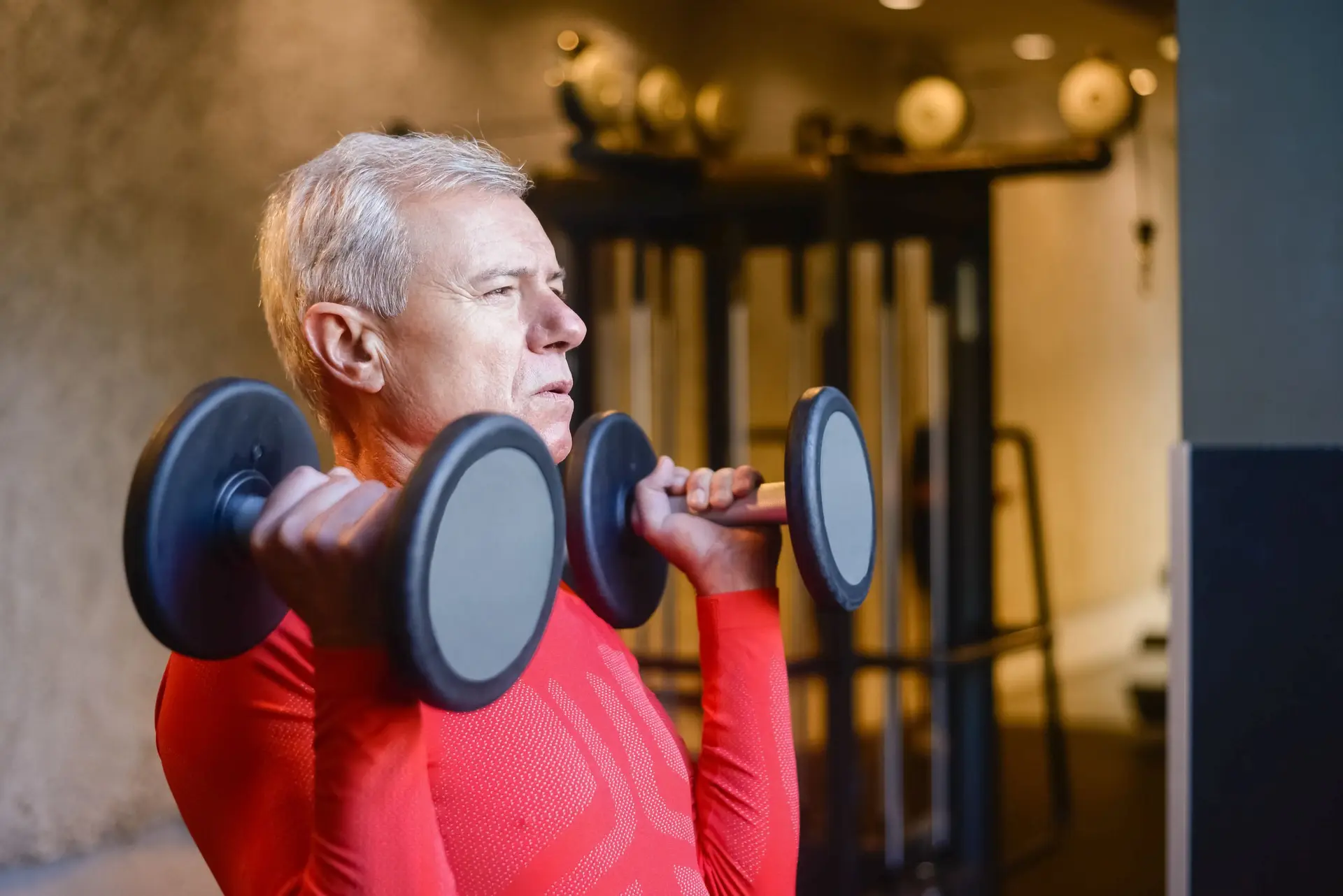 senior male client working out in condo gym with personal trainer in midtown toronto